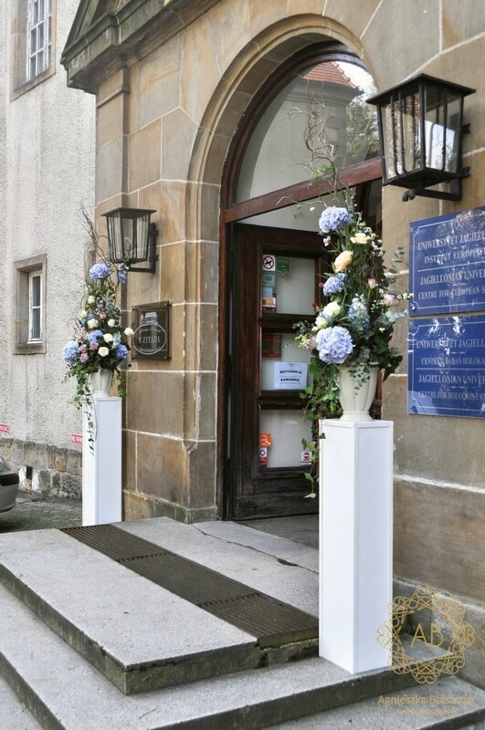 Dekoracja wejścia do Ziyada kompozycje kwiatowe na podestach błękitne hortensje kremowe róże lila ostróżki Agnieszka Błaszczyk abkwiaty