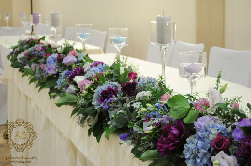 Girlanda z liści i niebieskich fioletowych kwiatów na stole pary młodej świece w szklanych kielichach Agnieszka Błaszczyk abkwiaty Kraków