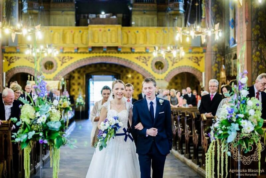 Dekoracja kościoła - wysokie kompozycje z białych, niebieskich i fioletowych kwiatów
